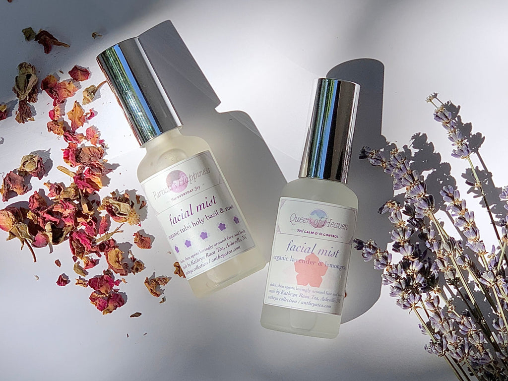 Two bottles of facial mist with dried flowers and lavender on a neutral background